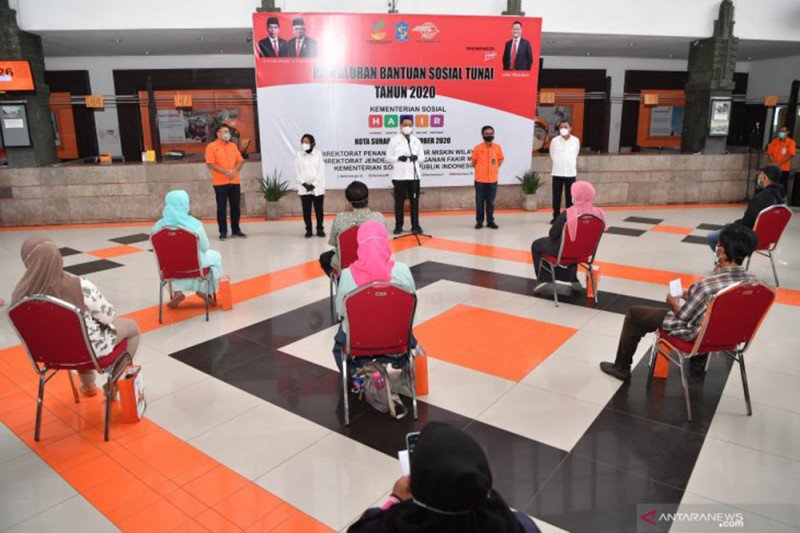  DOK/Menteri Sosial Juliari Batubara (tengah) didampingi Wali Kota Surabaya Tri Rismaharini (kedua kiri) beserta sejumlah pejabat di lingkup PT Pos memberikan pengarahan kepada warga penerima bantuan saat penyaluran Bantuan Sosial Tunai di Kantor Pos Sura