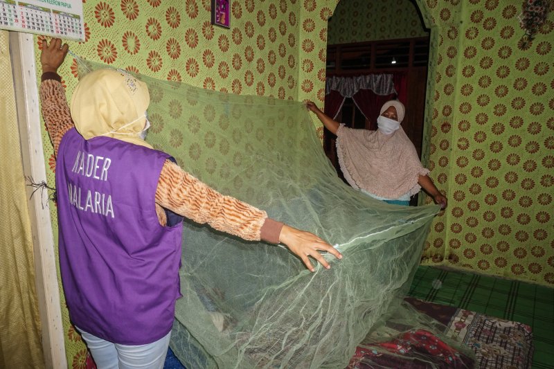 Seorang petugas mempraktekkan cara memasang kelambu Anti Nyamuk Malaria bersama salah satu warga di Kampung Arsopura, Distrik Skanto, Kabupaten Keerom, Papua, Selasa (20/10/2020). ant