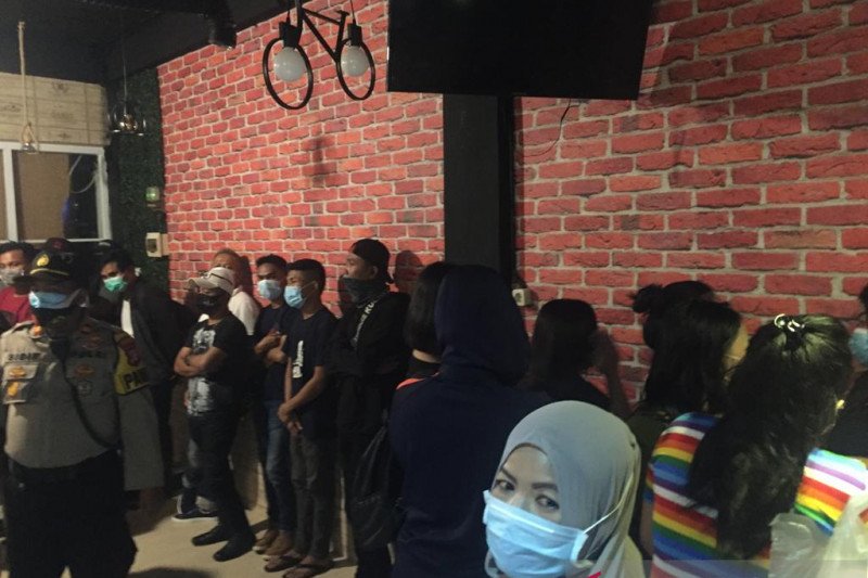 Petugas saat Operasi Yustisi COVID-19 Kebon Jeruk memboyong belasan perempuan dan laki-laki yang melanggar aturan PSBB di Panti Pijat Wijaya, Kebon Jeruk, Jakarta, Ahad (11/10/2020). (ANTARA/HO-Polres Metro Jakarta Barat)
