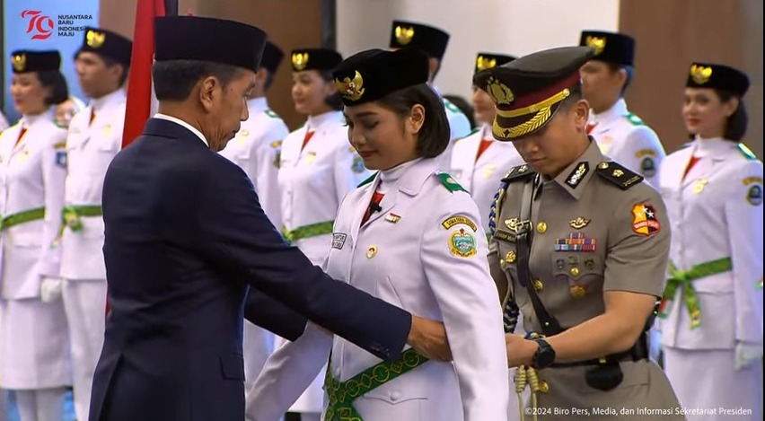 Presiden Joko Widodo (Jokowi) secara simbolis mengukuhkan Paskibraka Tingkat Pusat Tahun 2024 kepada Violetha Agryka Sianturi mewakili rekan-rekannya, di Istana Garuda, Ibu Kota Nusantara (IKN), Selasa (13/8/2024). (Foto: YouTube Sekretariat Presiden)

