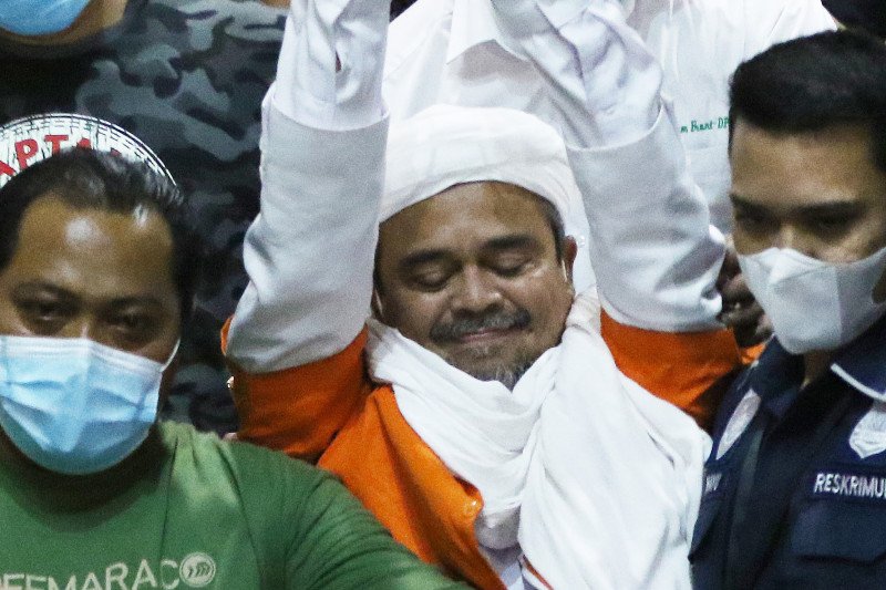 Imam Besar Front Pembela Islam (FPI) Habib Rizieq Shihab (tengah) berjalan menuju mobil tahanan usai diperiksa di Mapolda Metro Jaya, Jakarta, Minggu (13/12/2020) ANTARA FOTO/Reno Esnir/pras. * (ANTARA/RENO ESNIR)

