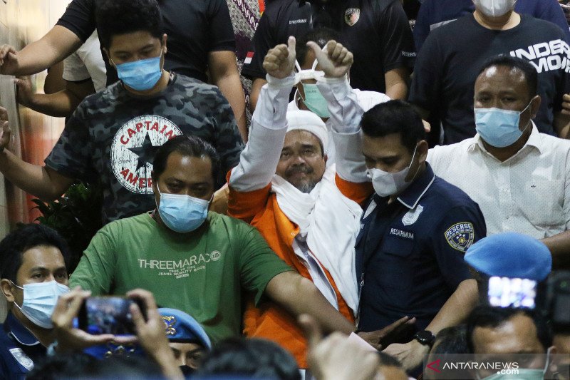 Imam Besar Front Pembela Islam (FPI) Habib Rizieq Shihab (tengah) berjalan menuju mobil tahanan usai diperiksa di Mapolda Metro Jaya, Jakarta, Minggu (13/12/2020). ANTARA FOTO/Reno Esnir/pras.

