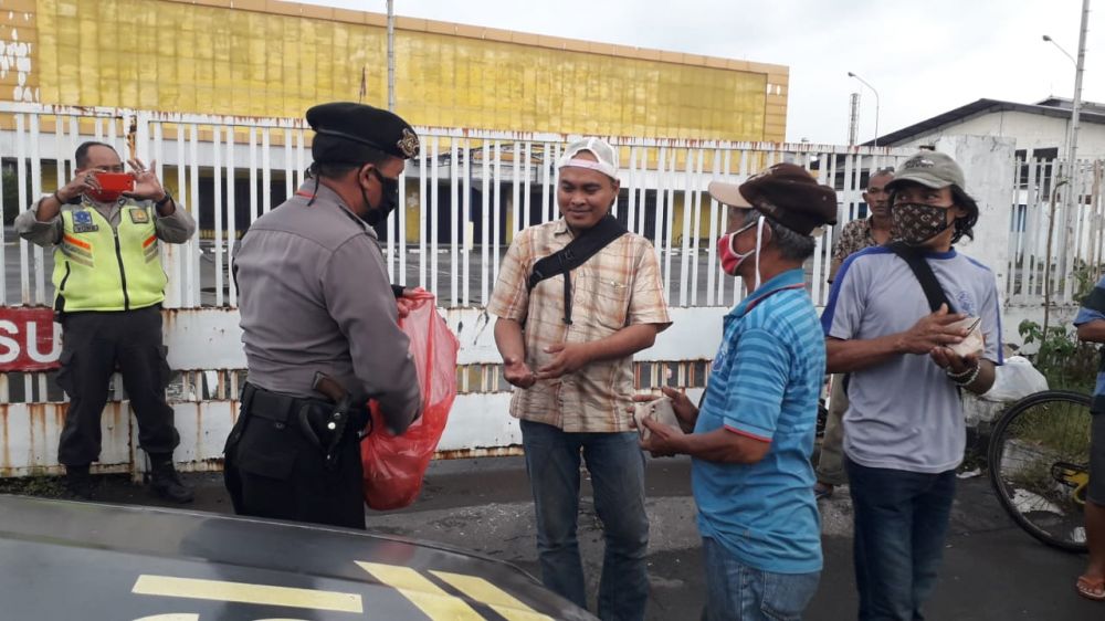 Bagi-bagi nasi bungkus Polsek Tenggilis kepada masyarakat yang membutuhkan. Foto : Prass?HMP