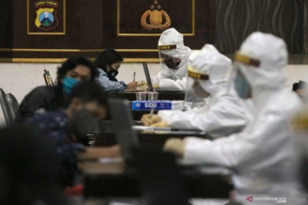 Petugas melakukan pemeriksaan cepat COVID-19 (Rapid Test) kepada warga yang terjaring razia pembatasan aktivitas malam hari di Polrestabes Surabaya, Minggu (3/5/2020) dini hari. (ANTARA Jatim/ Didik Suhartono)

