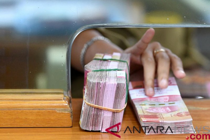 Karyawan memegang mata uang rupiah di gerai penukaran mata uang asing di Jakarta. (FOTO ANT)
