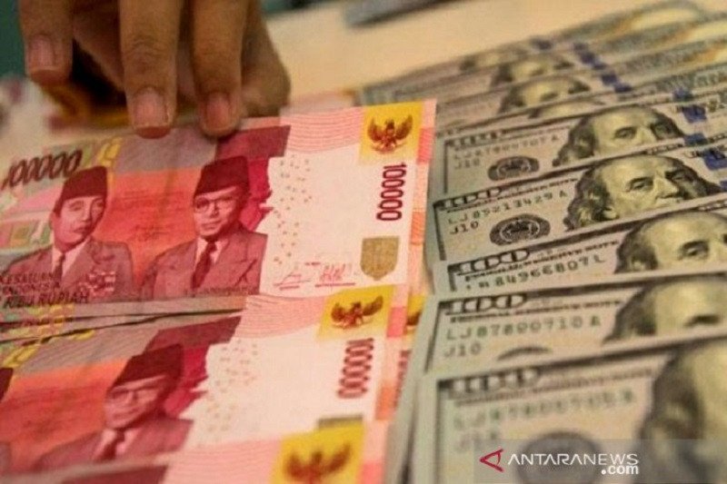  Ilustrasi. Pegawai bank menunjukkan mata uang rupiah dan dolar AS di Jakarta. ANTARA FOTO/Rosa Panggabean/pri. 