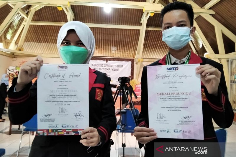 Mirza Tsabita Wafa'ana dan Muhammad Fariz Kautsar siswa kelas IX SMP 1 Kudus, Jawa Tengah, menunjukkan sertifikat perolehan medali perunggu dan perak saat mengikuti sejumlah kejuaraan inovasi sains. (ANTARA/Akhmad Nazaruddin Lathif)

