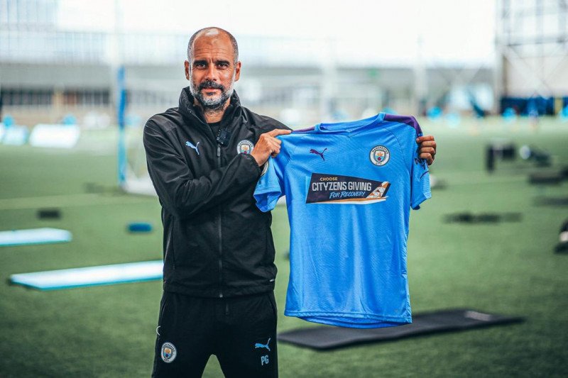 ep Guardiola memegang jersey khusus Manchester City yang akan digunakan lawan Arsenal. (skysports.com)