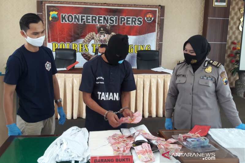Tukang sayur tersangka "pengganda uang" (tengah) menunjukkan barang bukti uang mainan pecahan Rp100.000, di Markas Polres Temanggung, Jawa Tengah, Kamis. ANTARA/Heru Suyitno