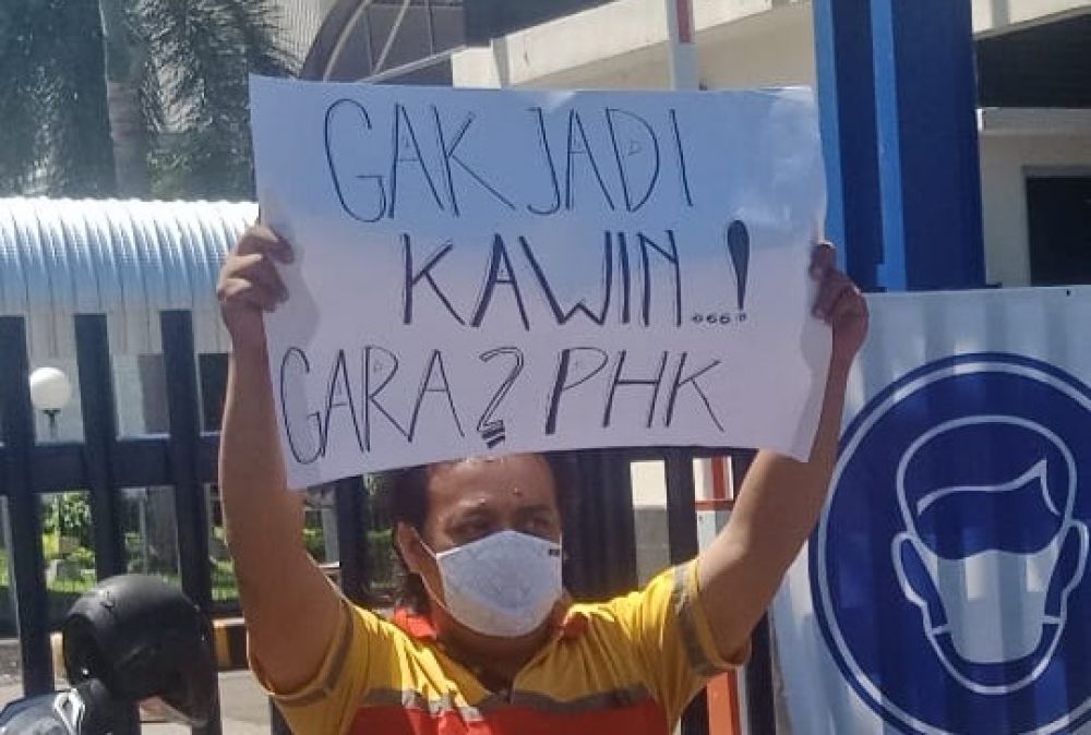Karyawan membentangkan poster saat menggelar unjuk rasa bersama belasan karyawan lainnya di depan pabrik PT Unilever Indonesia di kawasan Rungkut, Surabaya. 