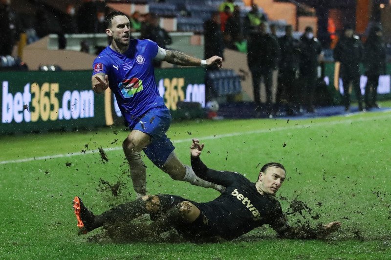Pemain Stockport County Liam Hogan berebut bola dengan pemain West Ham United Mark Noble pada babak ketiga Piala FA yang digelar di Edgeley Park, Stockport, Inggris, Senin (11/1/2021) (Pool via Reuters/Martin Rickett)


