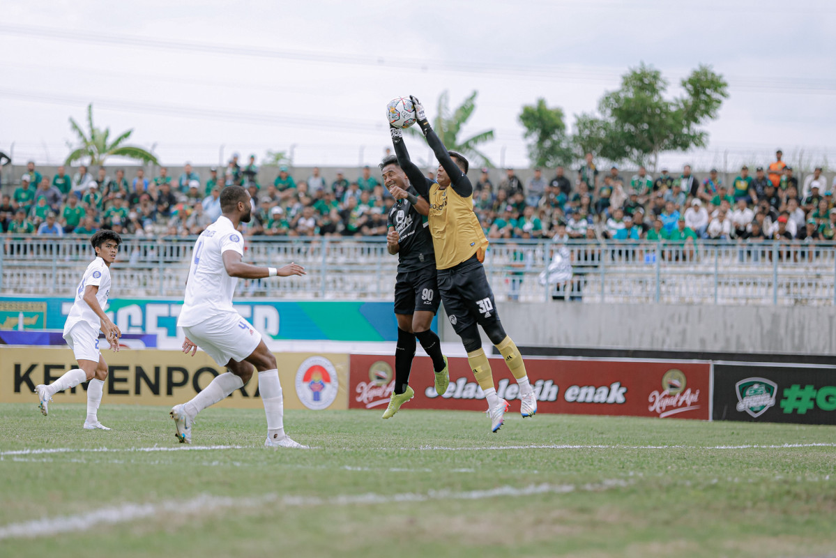 Januar Eka duel udara dengan kiper PSM Makassar Reza Arya. (Persebaya)
